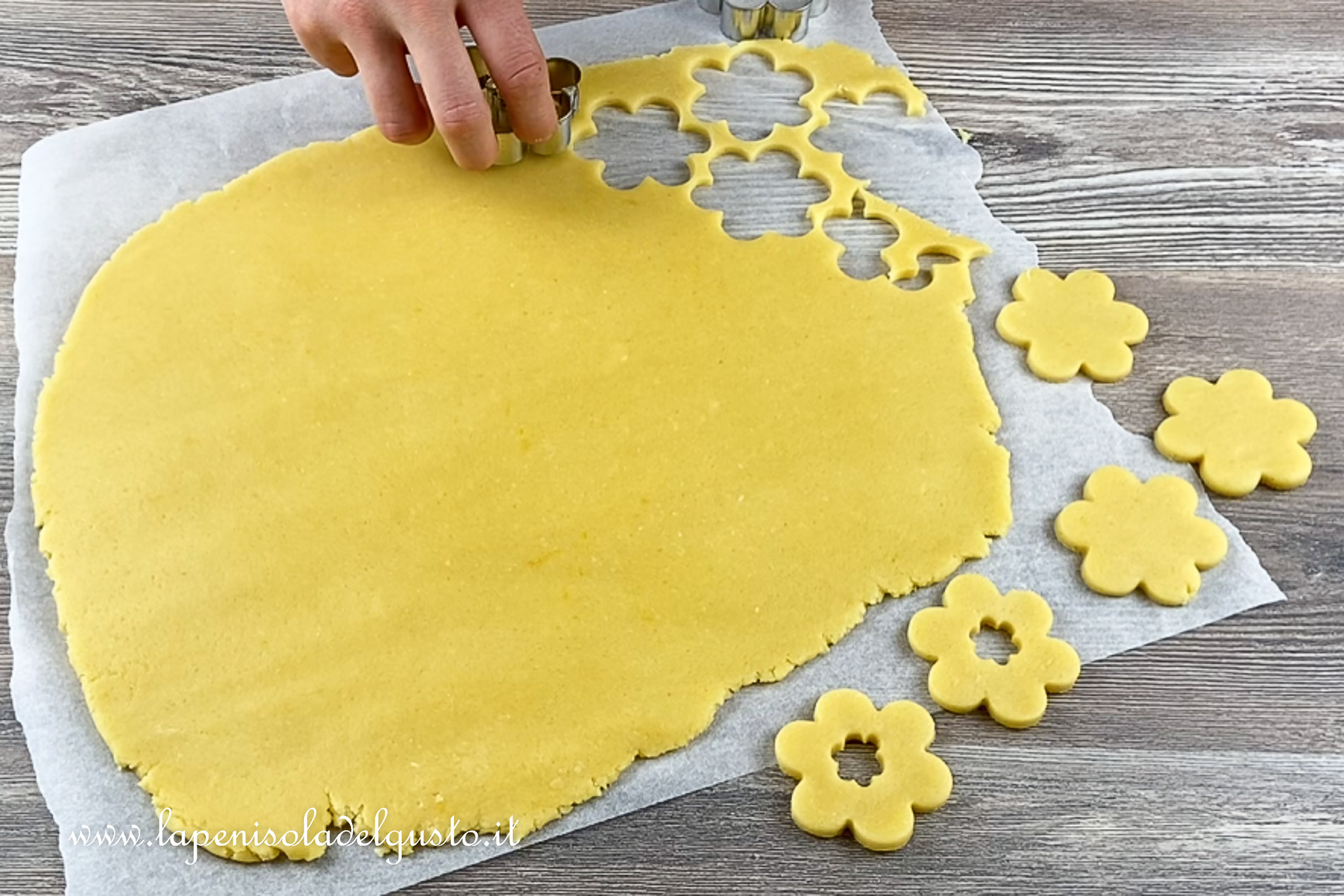 taglio i biscotti di pasta frolla con lo stampo a fiore per cuocerli