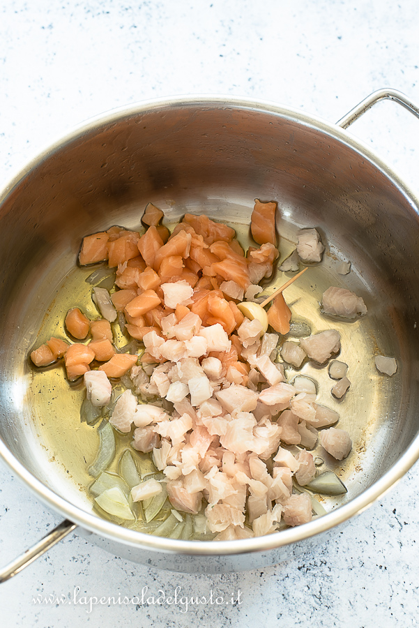 Cuocio il salmone e il pesce spada in padella per preparare la pasta